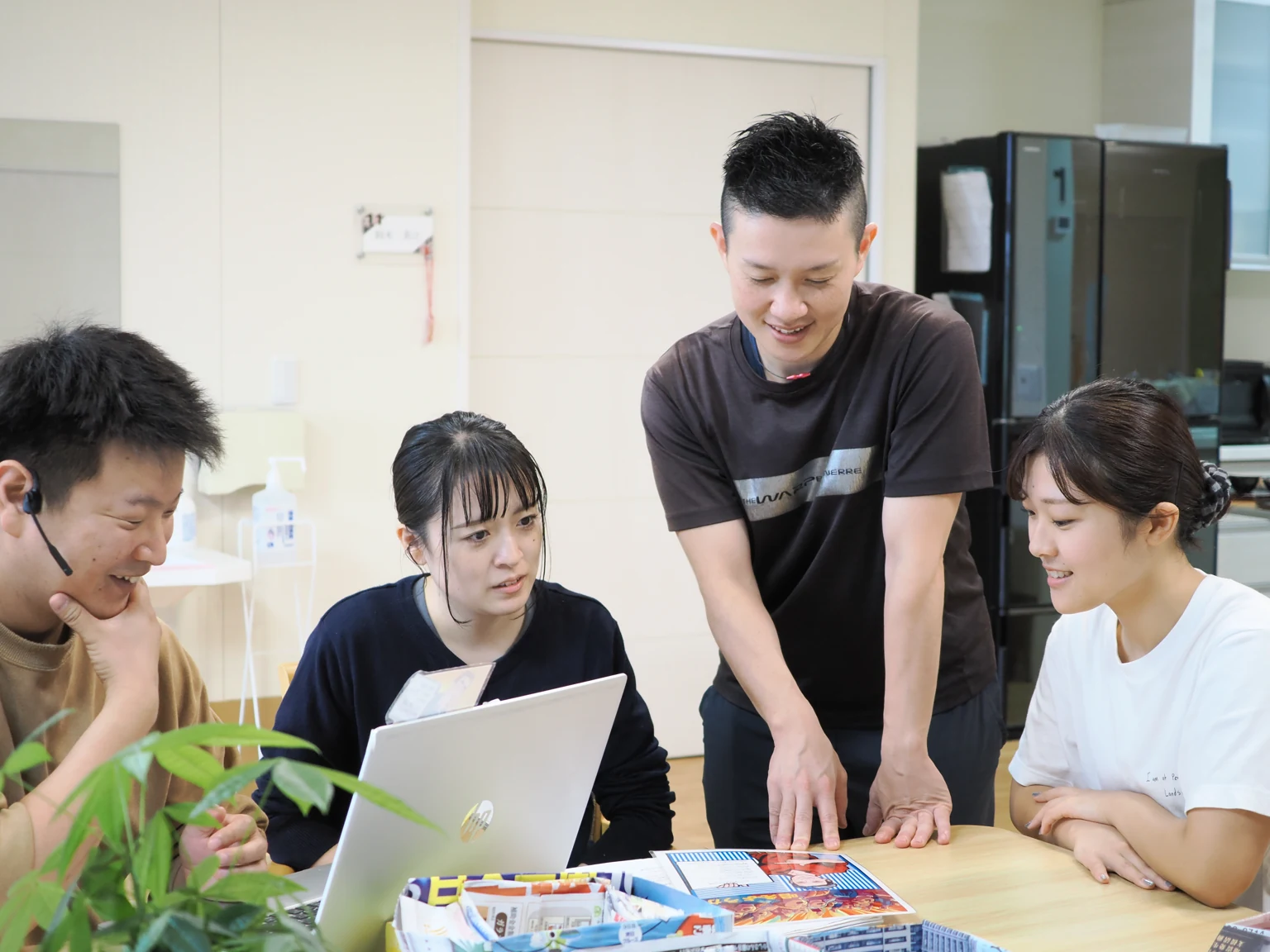 職員インタビュー01。テーブルを囲んで話し合う職員たち