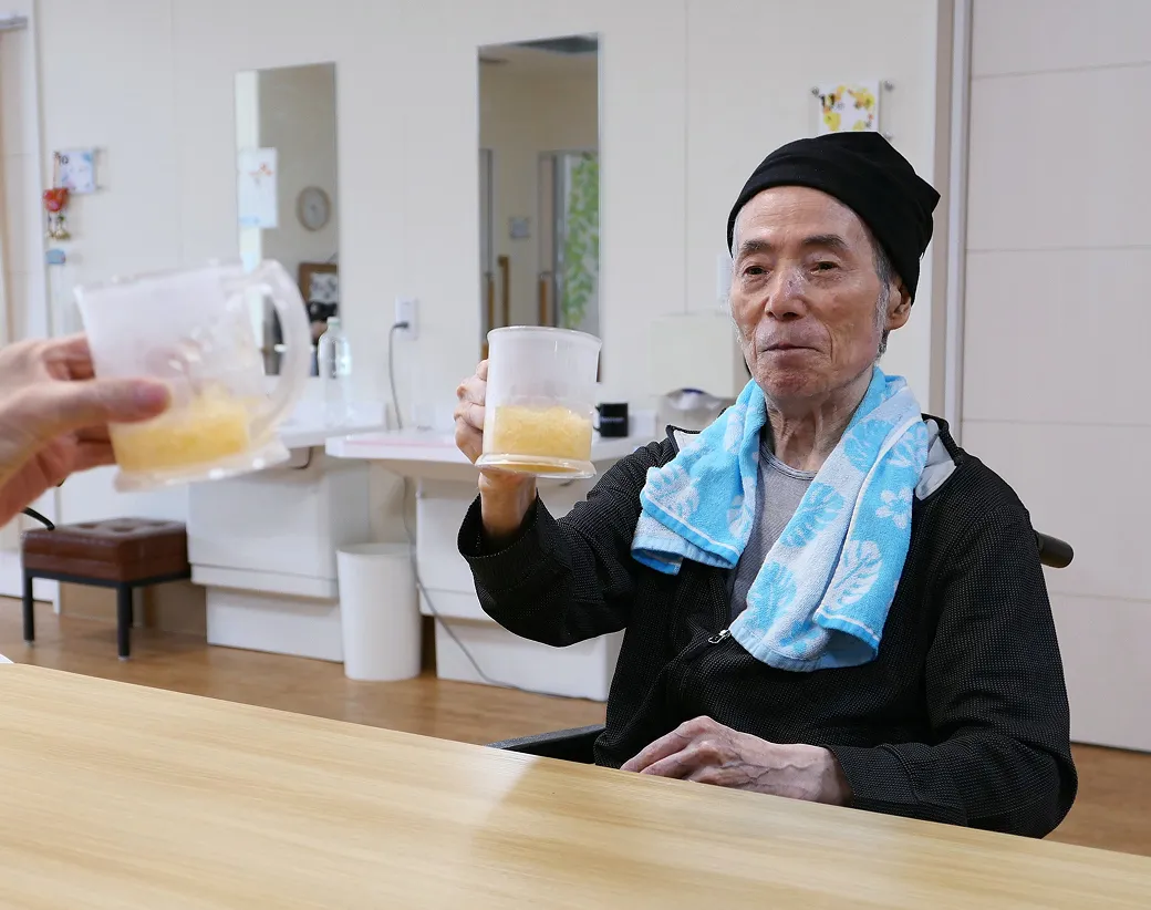 飲み物を手に食事の時間を楽しむ入居者さま