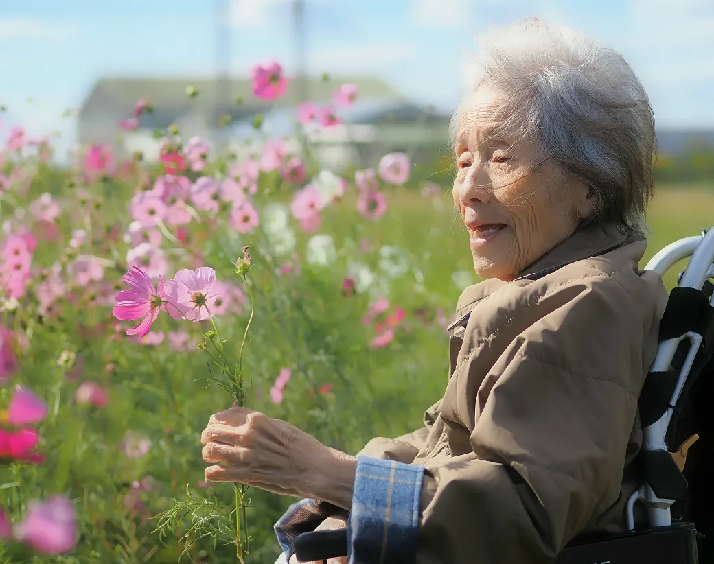 屋外で季節の花を楽しむ入居者さま